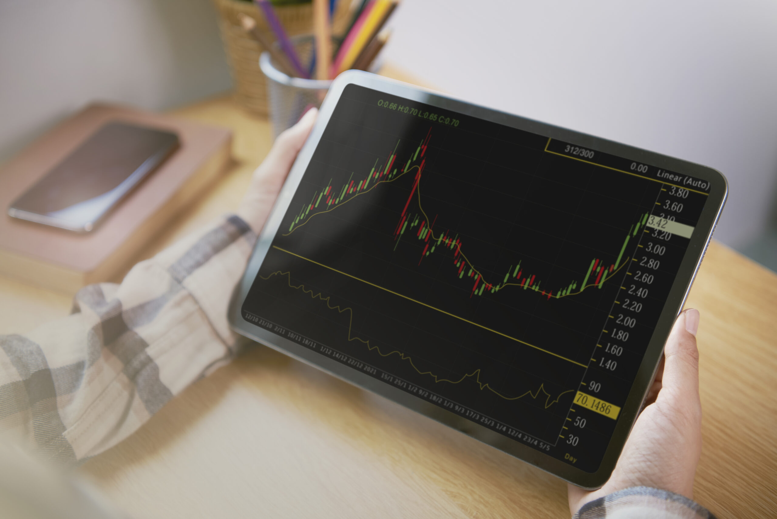 Businesspeople analyzing financial charts on a tablet, indicating market volatility and crypto sell-off.