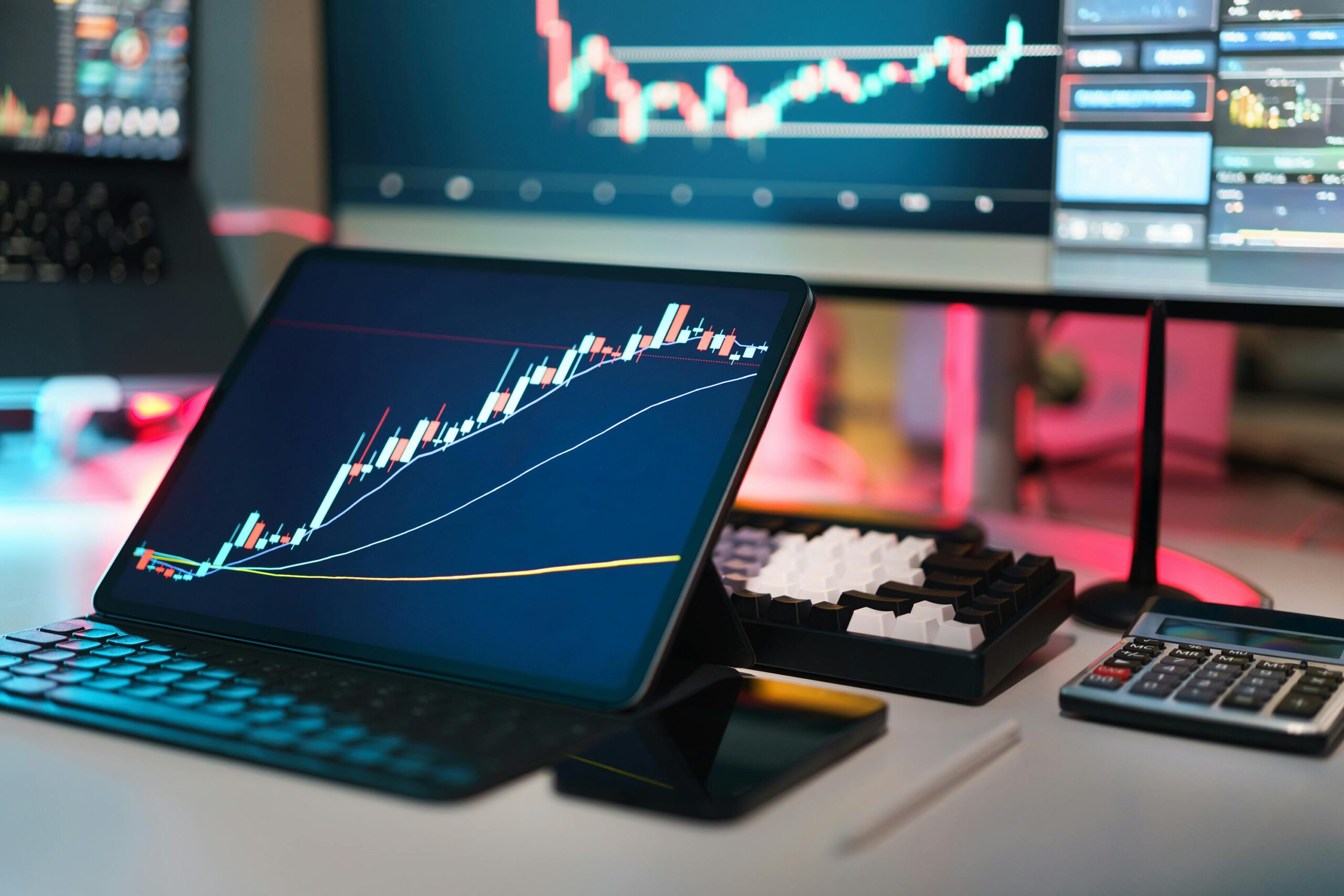 Trading desk with laptop and multiple monitors displaying crypto charts, indicating market volatility.