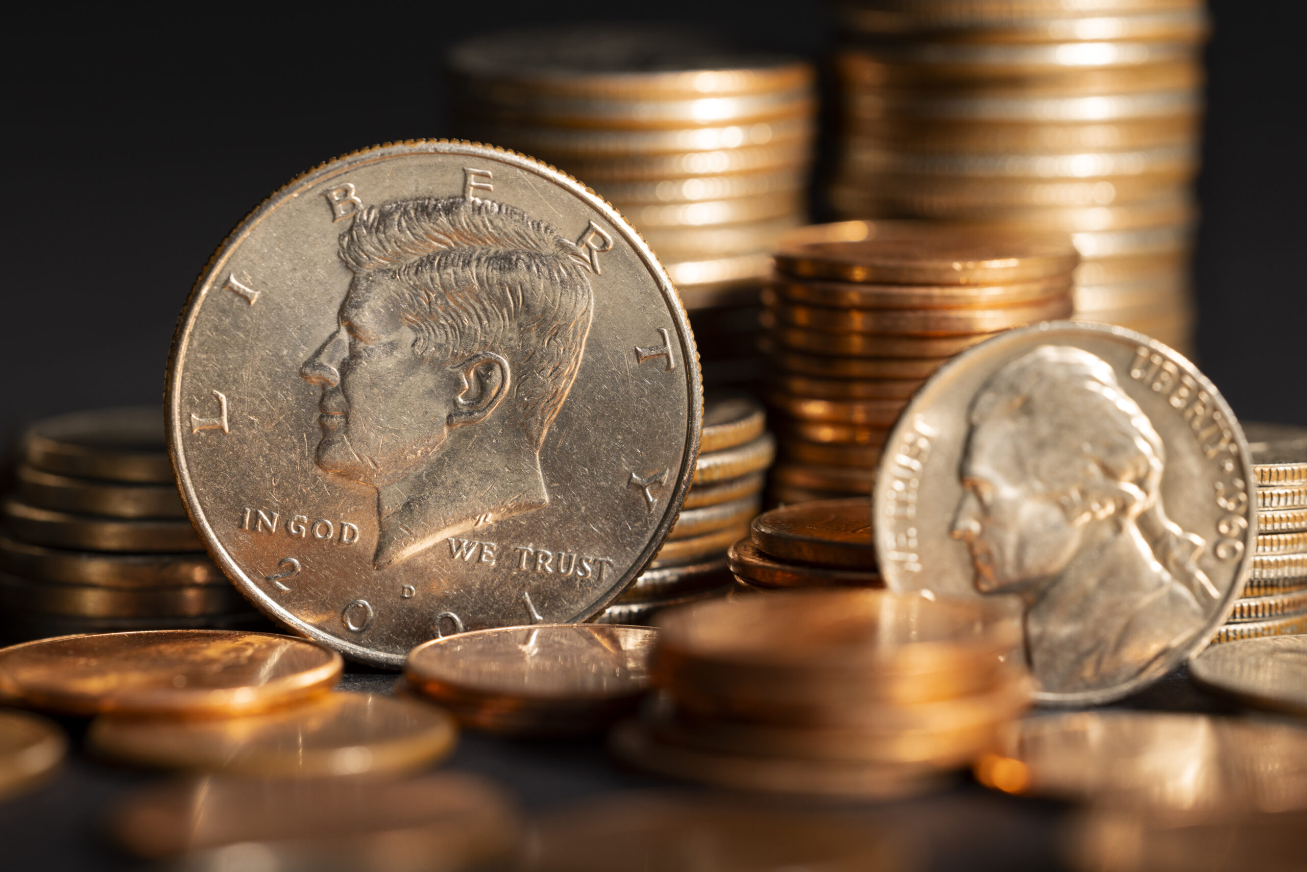 Stacks of U.S. dollar coins symbolizing economic policy shifts and their influence on digital asset adoption.